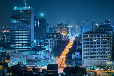 Illuminated buildings in city against sky at night