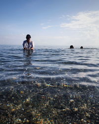 Man in sea against sky