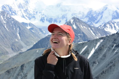 Portrait of young woman standing against snowcapped mountain