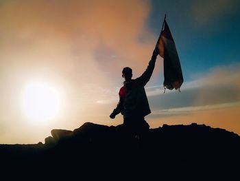 Low angle view of silhouette man standing against sky during sunset