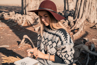 Midsection of woman holding hat