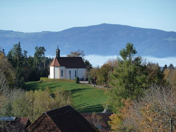 Scenic view of houses and trees against sky