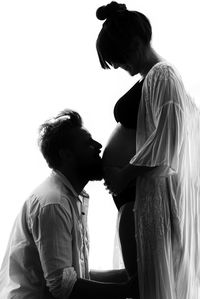 Side view of young couple standing against wall