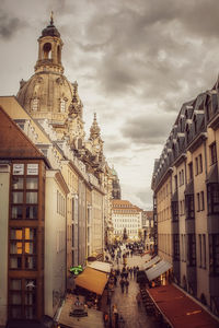 Cars on street in city against sky