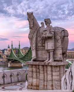 Statue of saint stephen i in budapest with the liberty bridge in background