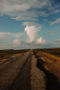 Road leading towards landscape against sky