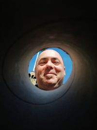 Low angle view of man looking through hole