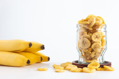 Close-up of fruits in jar against white background