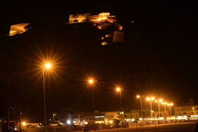 Illuminated city against sky at night