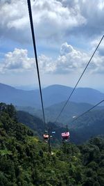 Overhead cable car over mountains against sky