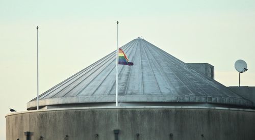 Low angle view of flag on building against clear sky