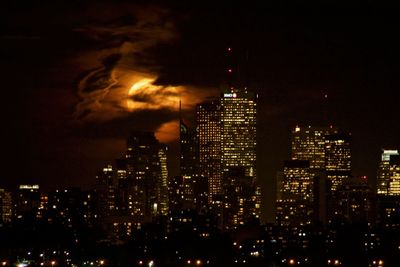 Illuminated city against sky at night