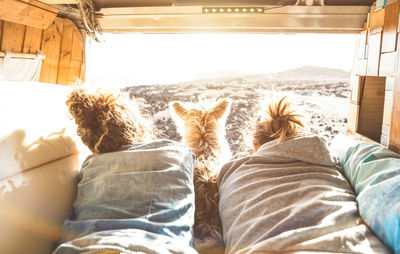 Rear view of woman relaxing on bed