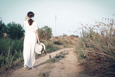 Woman standing by plants against sky