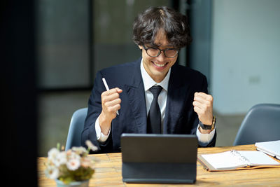 Businesswoman using mobile phone while sitting at office