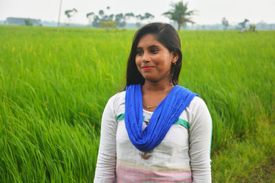 Portrait of young woman standing on field