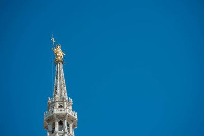 Low angle view of statue of building against blue sky