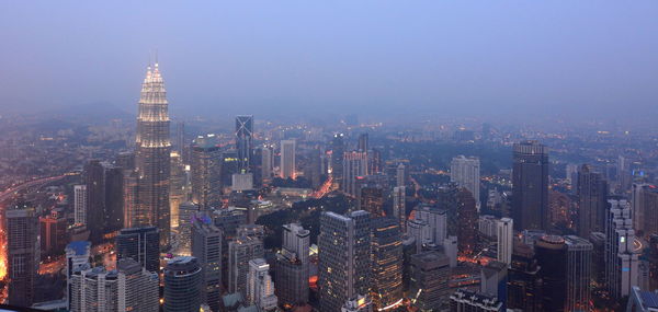 Aerial view of illuminated cityscape against sky