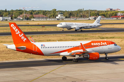 Airplane on airport runway against sky