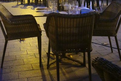 Empty chairs and tables in illuminated building