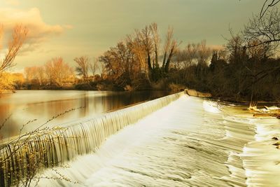 Scenic view of lake against sky at sunset