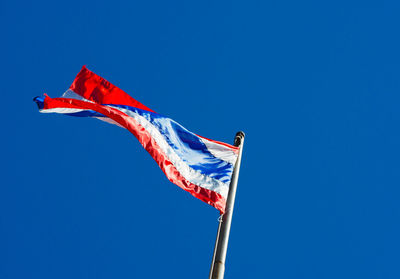 Low angle view of flags flag against clear blue sky