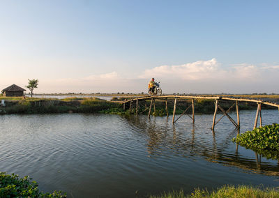 People on bridge against sky