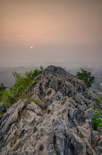 Rock formation on sea against sky during sunset