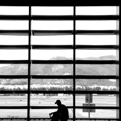 Silhouette man standing by sea against sky