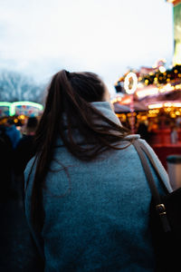 Rear view of woman in city against sky