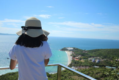 Rear view of woman looking at sea against sky