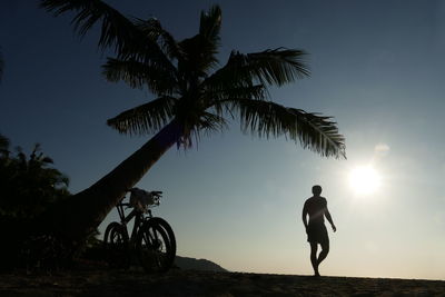 Rear view of man walking at beach against sky