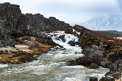 Scenic view of waterfall against sky