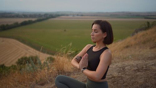 Young woman sitting on field