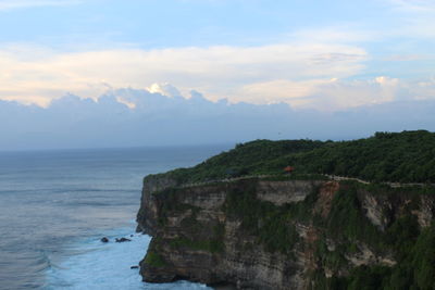 Scenic view of sea by cliff against sky