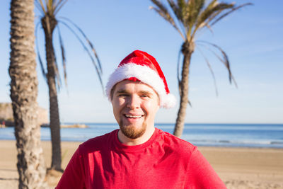 Portrait of smiling mid adult man at beach against sky