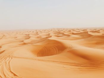 Sand dunes in desert against clear sky