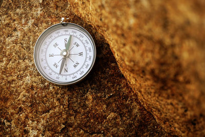 Close-up of navigational compass on rock