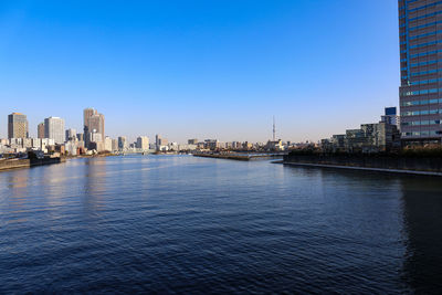 Wide angle view of sumida river with skyscrapers under blue morning sky in tokyo