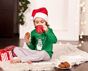 Portrait of cute girl eating food on bed at home