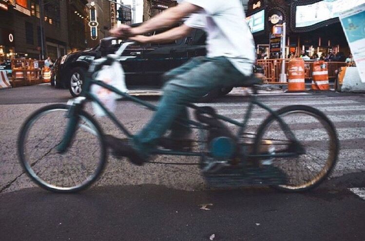 LOW SECTION OF MAN RIDING BICYCLE ON STREET