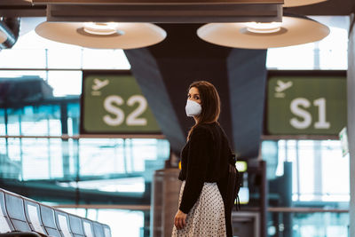 Portrait of smiling woman wearing mask at airport