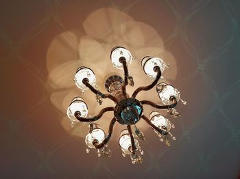 Low angle view of illuminated light bulb hanging at home