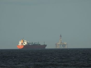 Ship sailing in sea against clear sky