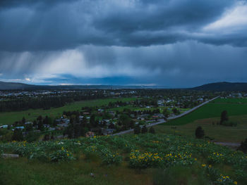 Scenic view of field against storm clouds