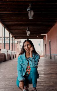 Portrait of woman standing against wall