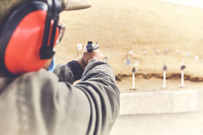 Man with hand gun aiming at shooting range and releasing stress. selective focus
