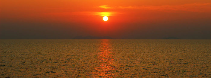 Scenic view of sea against orange sky