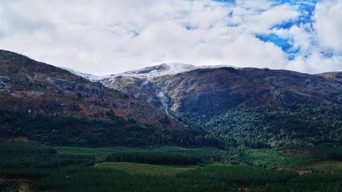 Scenic view of mountains against cloudy sky