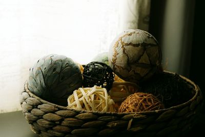 Close-up of decorations in wicker basket on window sill at home